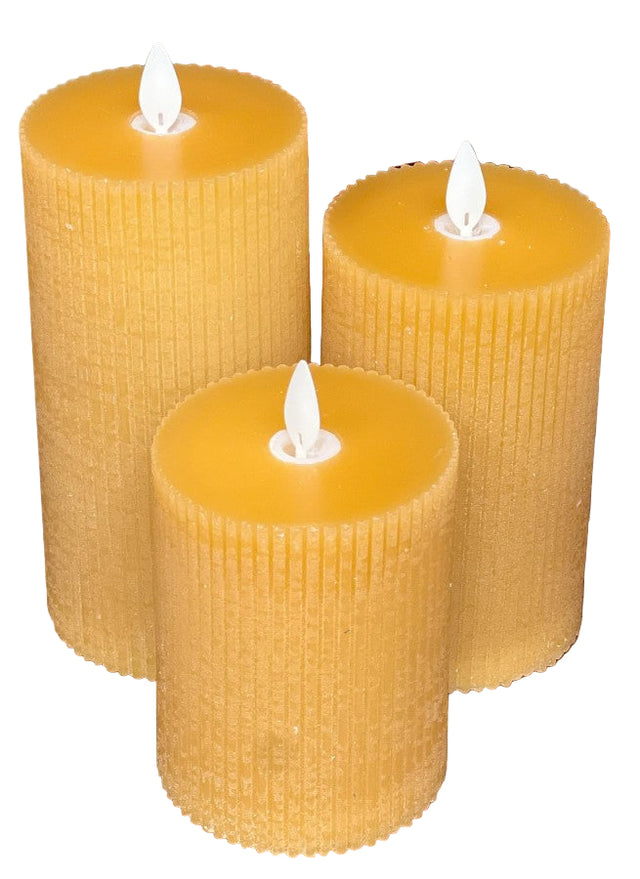 Three vertical yellow pillar candles with a realistic flame effect, displayed against a fall-themed backdrop with leaves.